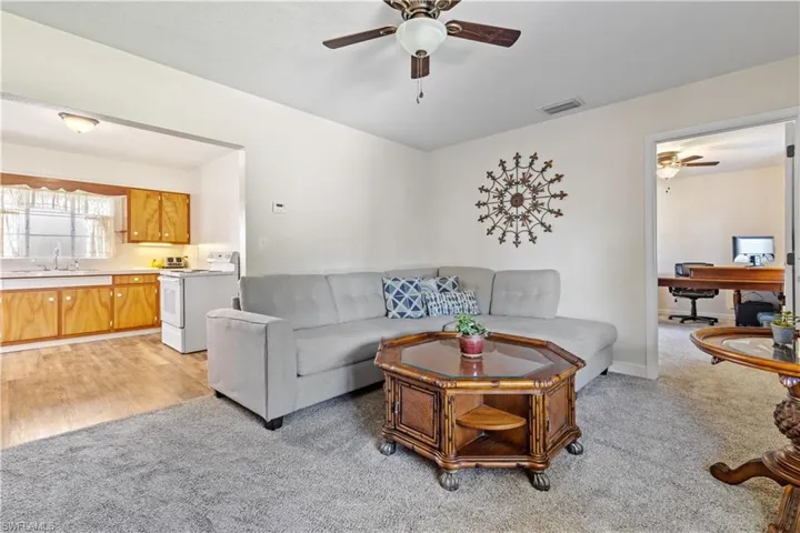 Carpeted living room with sink and ceiling fan