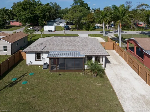 Back of house featuring a sunroom, central air condition unit, and a yard