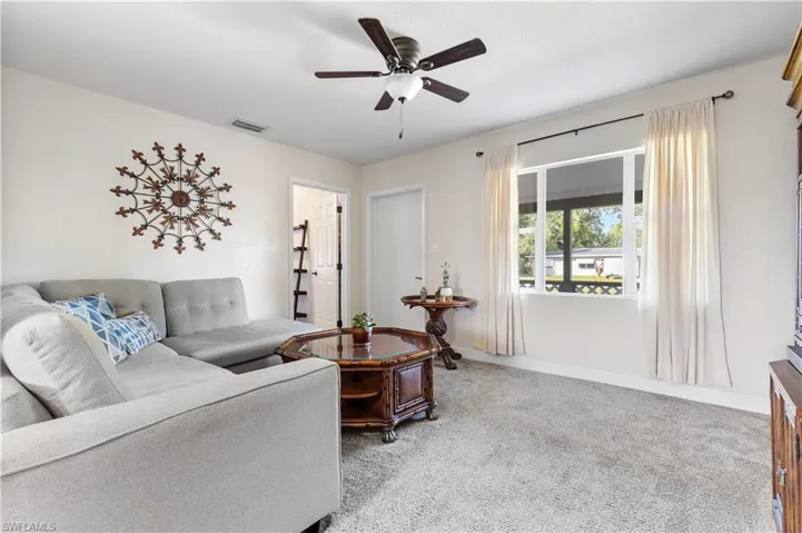 Living room featuring light colored carpet and ceiling fan
