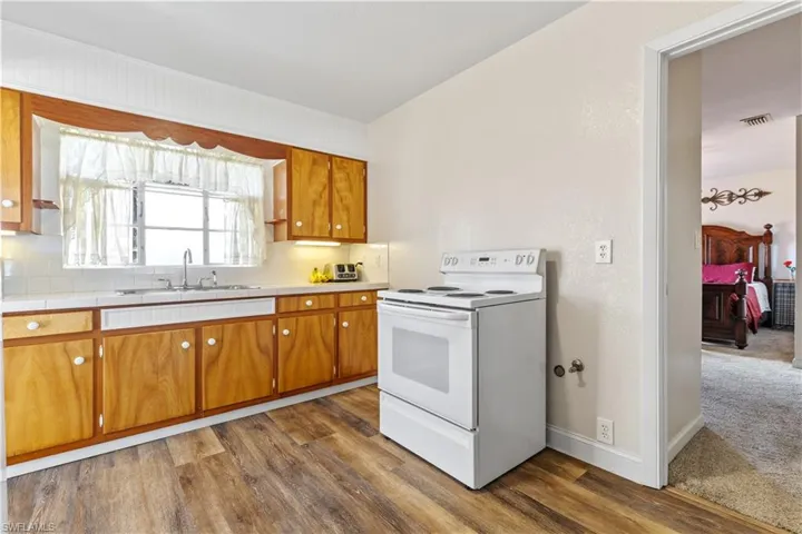 Kitchen featuring carpet, sink, and white electric range oven