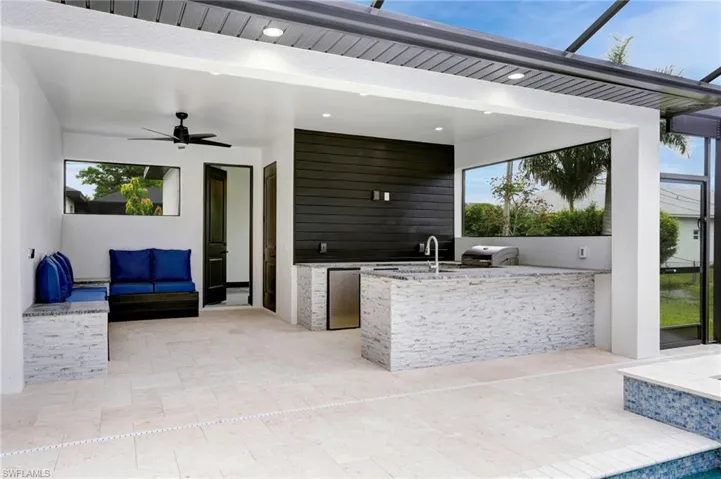 View of patio with exterior kitchen, sink, and ceiling fan