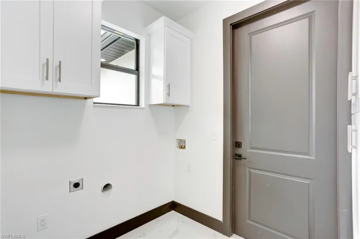 Laundry area with washer hookup, tile patterned flooring, cabinets, and electric dryer hookup