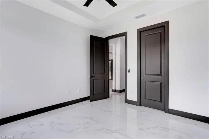 Empty room with light tile patterned floors and ceiling fan