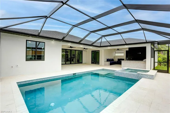 View of pool with ceiling fan, a lanai, an in ground hot tub, and a patio area