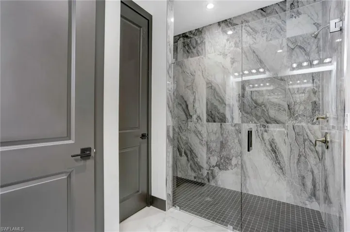 Bathroom featuring tile patterned floors and a shower with door
