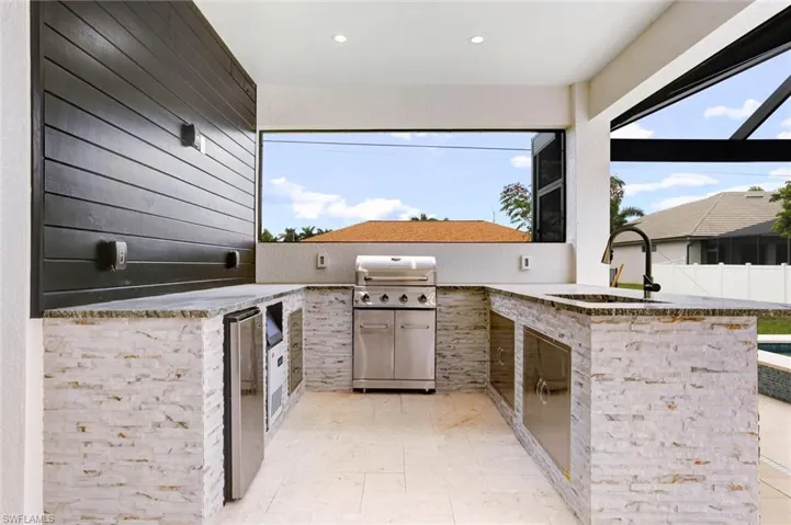 View of patio with a grill, sink, and an outdoor kitchen