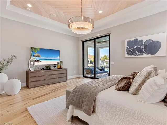 Bedroom with access to outside, a tray ceiling, and wood ceiling