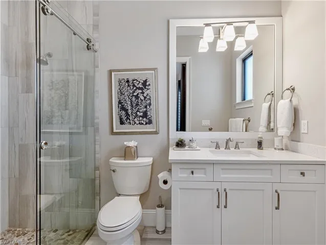 Bathroom with vanity, toilet, and walk in shower