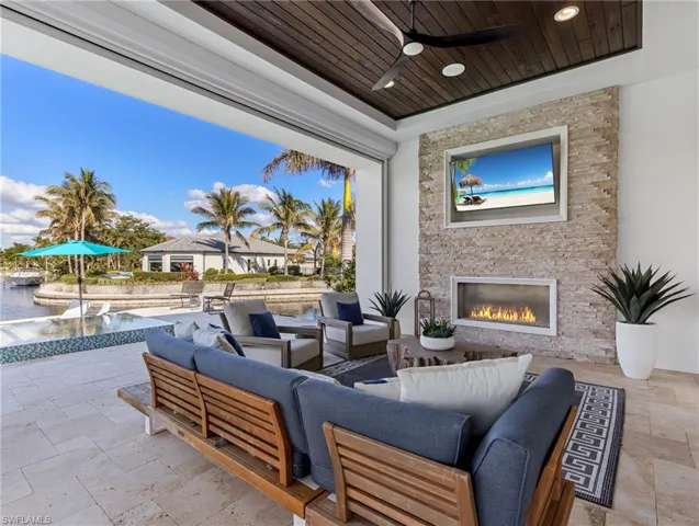 View of patio / terrace with an outdoor living space with a fireplace, a pool, and ceiling fan