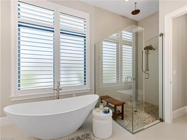 Bathroom with tile patterned flooring and independent shower and bath