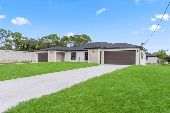 Single-story exterior featuring light-toned stucco and horizontal siding, dark shingled roof, attached three-car garage, and concrete driveway