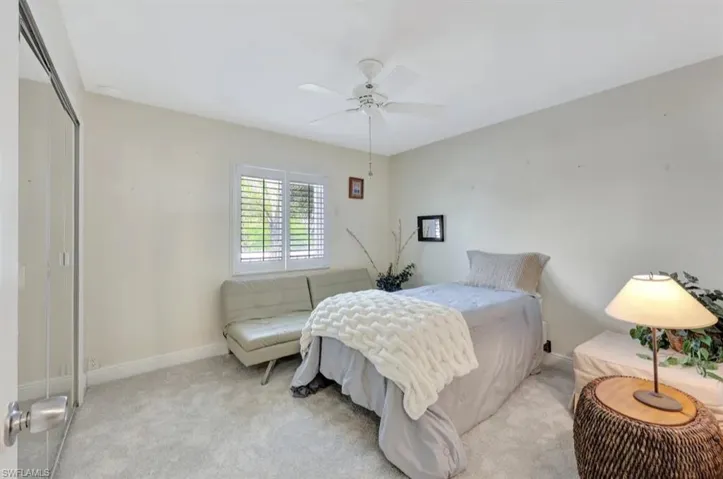 Bedroom with a closet, carpet, and ceiling fan