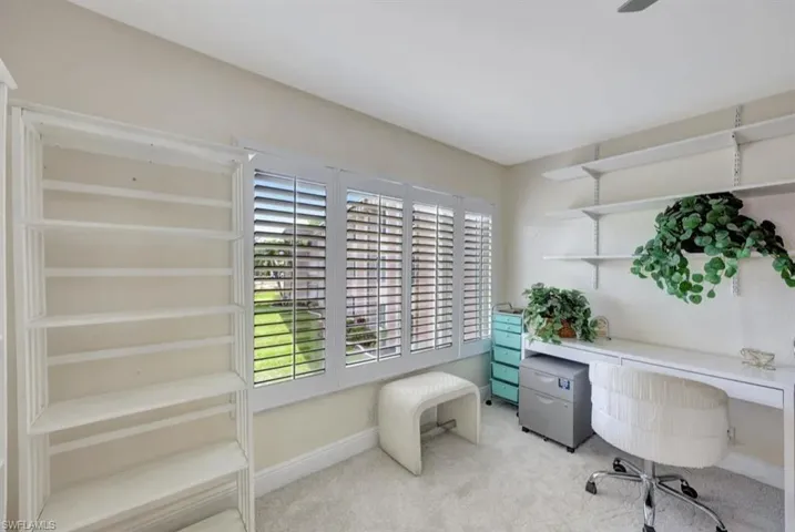 Office area featuring baseboards and light carpet