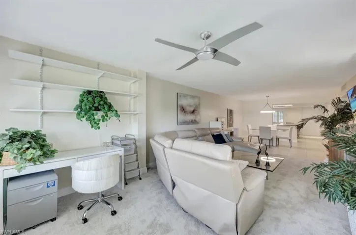 Tiled living area with carpet and ceiling fan