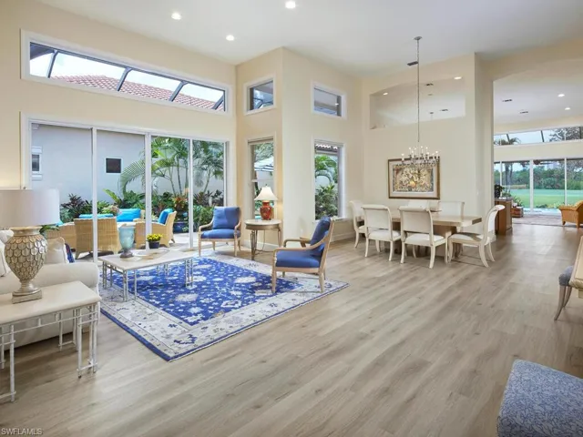 Living room with light hardwood / wood-style flooring and a high ceiling