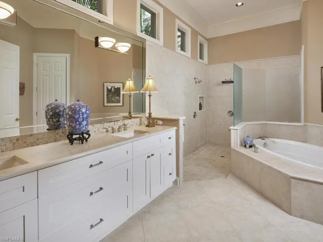 Bathroom featuring shower with separate bathtub, vanity, and ornamental molding