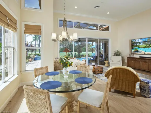 Dining space with a notable chandelier, crown molding, and light hardwood / wood-style floors