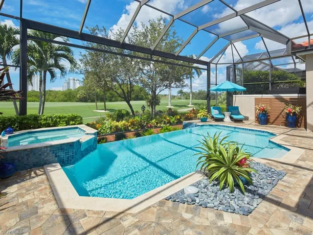 View of swimming pool with glass enclosure, an in ground hot tub, and a patio area