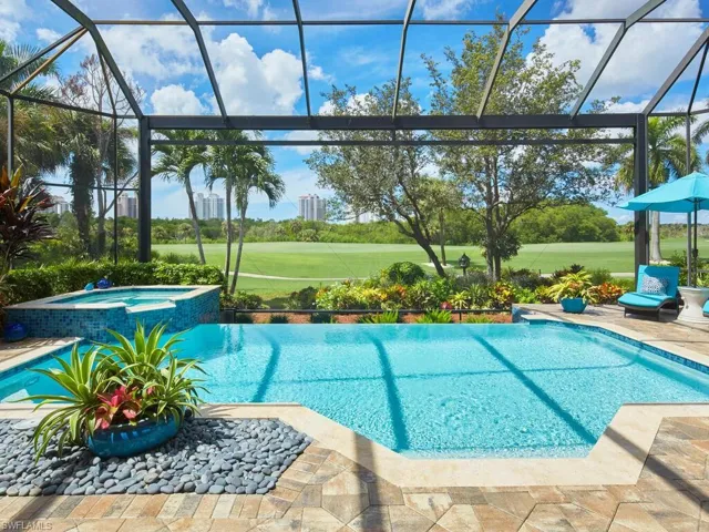 View of pool featuring glass enclosure, an in ground hot tub, and a patio area