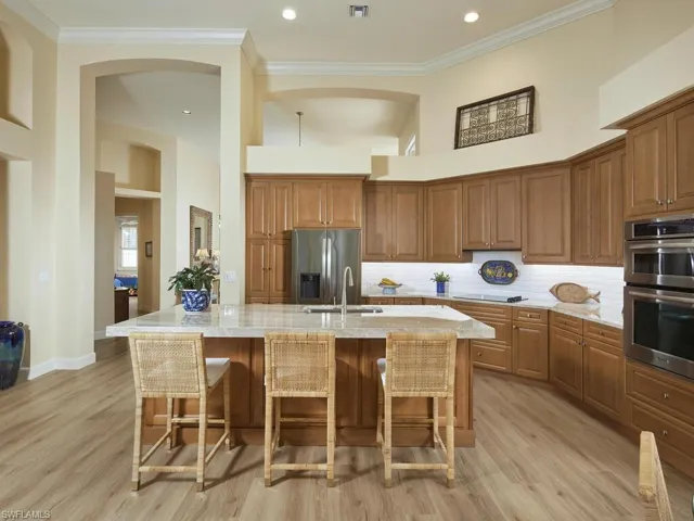 Kitchen featuring an island with sink, stainless steel appliances, and light hardwood / wood-style flooring