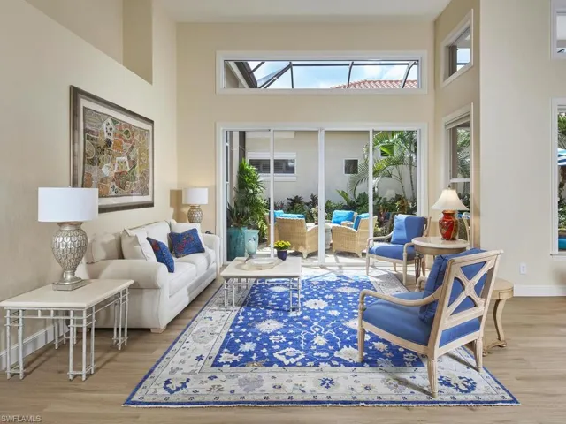 Living room with light wood-type flooring and a high ceiling