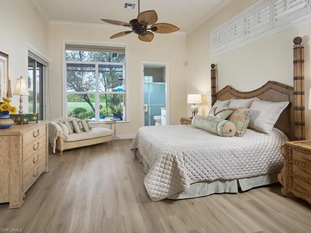 Bedroom with ceiling fan, ornamental molding, connected bathroom, and light hardwood / wood-style floors