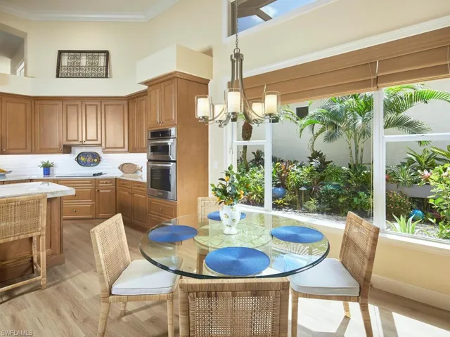 Dining area with a high ceiling, a chandelier, and plenty of natural light