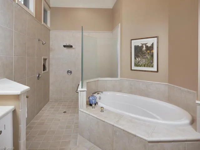 Bathroom with shower with separate bathtub, tile patterned floors, and vanity