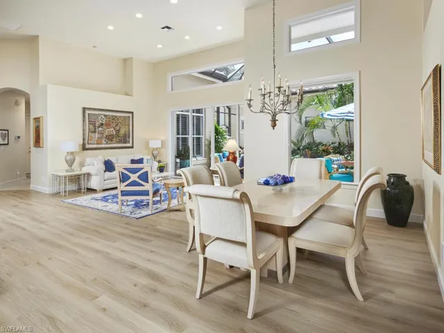 Dining space with a high ceiling, light hardwood / wood-style floors, and a wealth of natural light