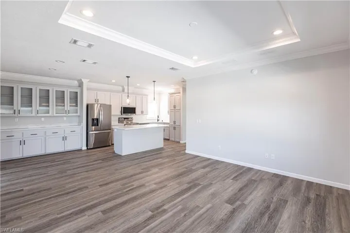 Kitchen with glass insert cabinets, open floor plan, recessed lighting, a kitchen island, and stainless steel appliances