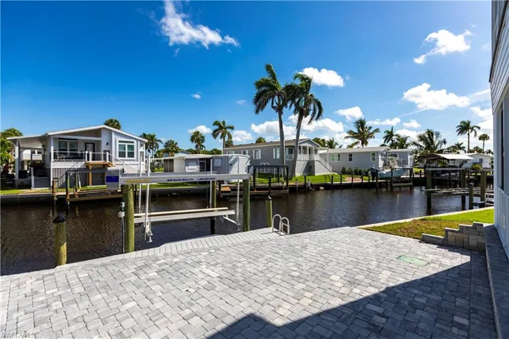 Dock area with a residential view, a water view, and boat lift