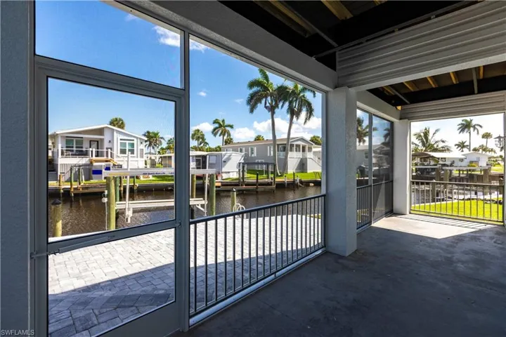 Unfurnished sunroom with a water view and a residential view