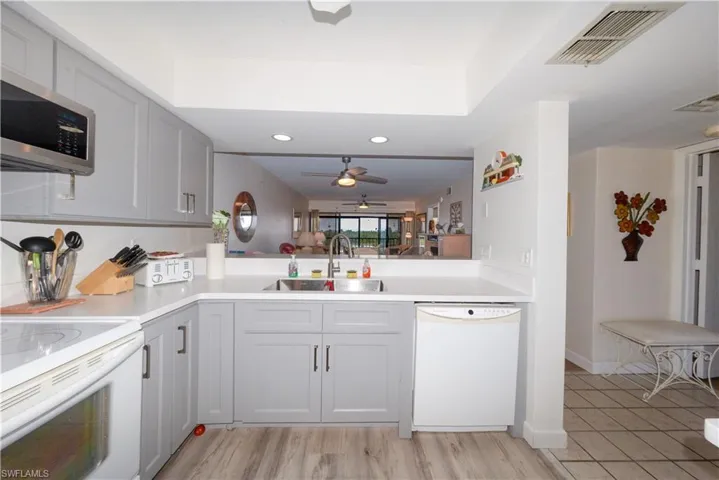 Kitchen with white appliances, gray cabinetry, ceiling fan, light countertops, and recessed lighting