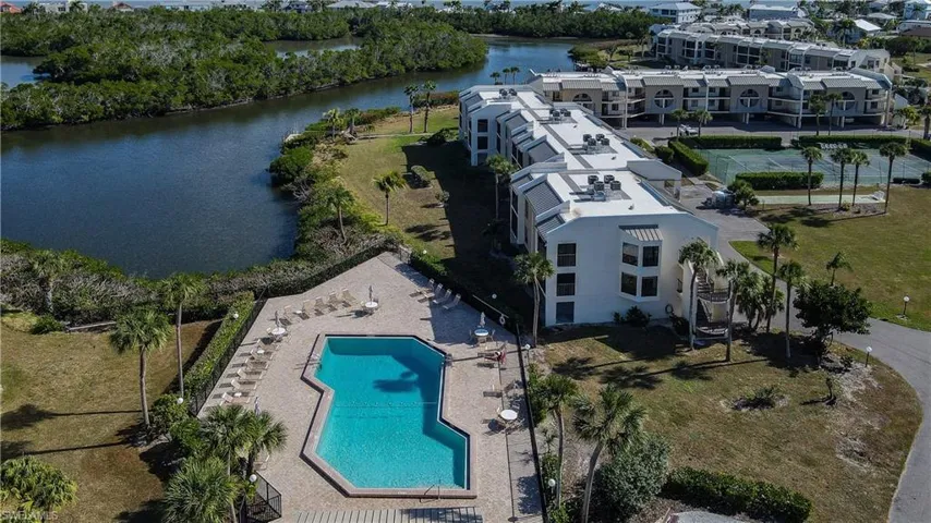 Aerial view of a pool area and a large body of water