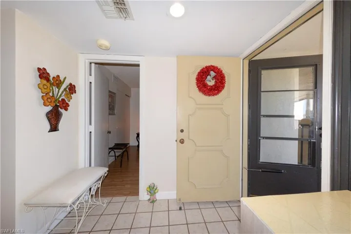 Entrance foyer with light tile patterned flooring and baseboards
