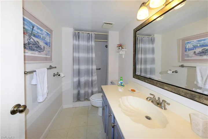 Bathroom with vanity, curtained shower, and light tile patterned flooring