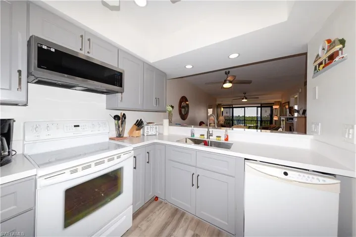 Kitchen featuring white appliances, gray cabinetry, recessed lighting, light countertops, and ceiling fan