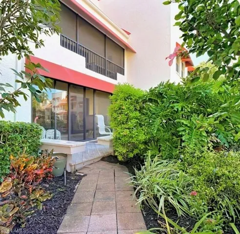 Rear view of property with a sunroom, stucco siding, and a balcony