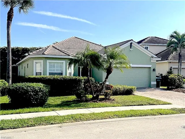 View of front of property featuring an attached garage, stucco siding, a tile roof, and decorative driveway