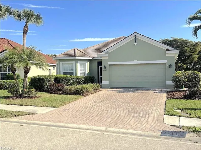Ranch-style house featuring stucco siding, an attached garage, decorative driveway, and a tiled roof