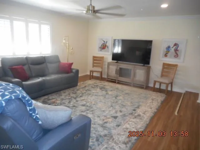 Living area with wood finished floors, a ceiling fan, crown molding, and recessed lighting