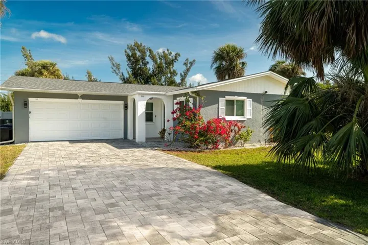 Single story home with stucco siding, an attached garage, a front lawn, and decorative driveway