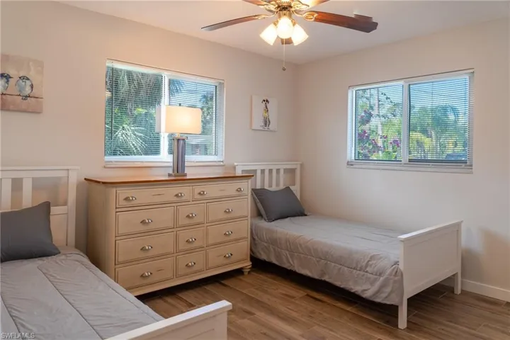 Bedroom with baseboards, a ceiling fan, and dark wood finished floors