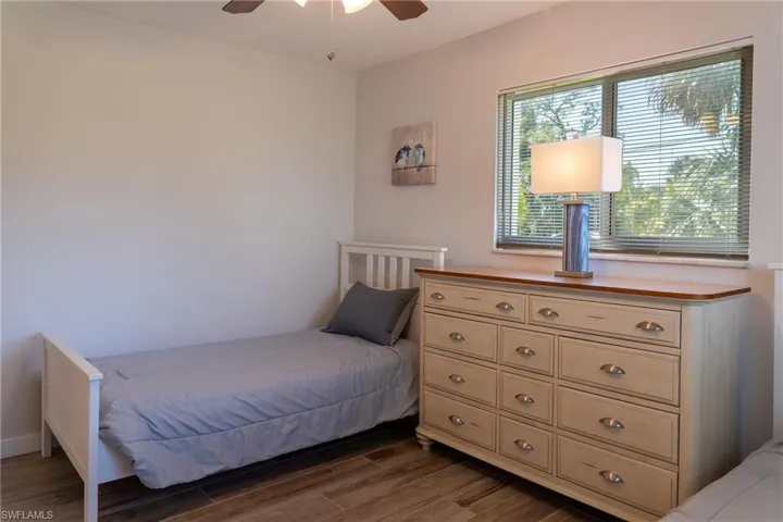Bedroom with dark wood-style floors and a ceiling fan