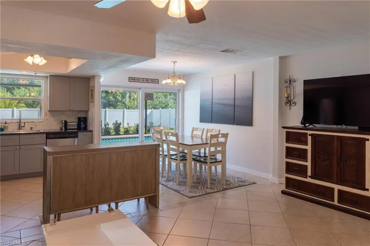 Kitchen with gray cabinetry, a sink, tasteful backsplash, and dishwasher