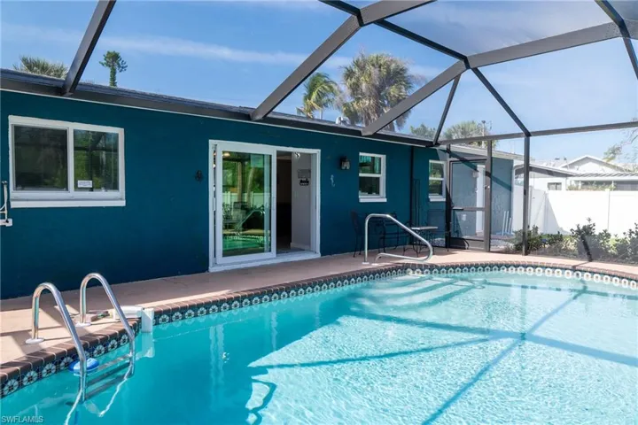 Outdoor pool featuring a patio, fence, and a lanai