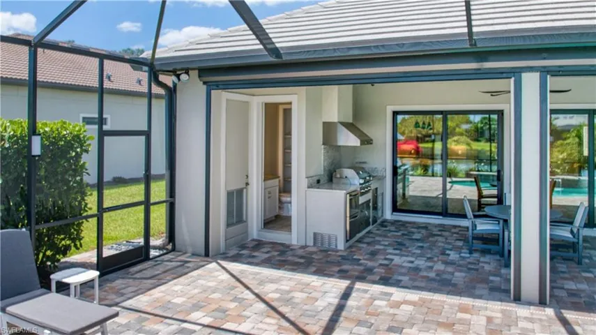 pool bath, pool equipment closet, outdoor kitchen and storm screen