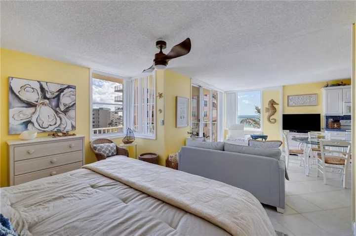 Bedroom with a textured ceiling, ceiling fan, and light tile patterned floors