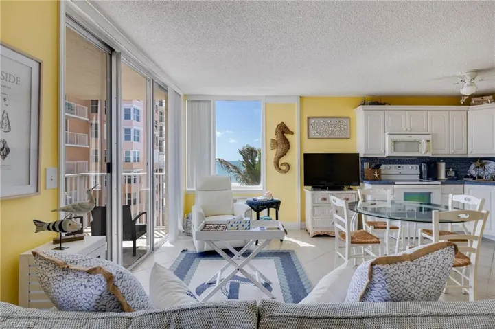 Living room featuring light tile patterned floors, a textured ceiling, and floor to ceiling windows
