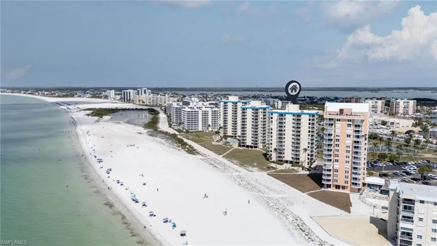 Drone / aerial view of unending shoreline and apartment complex